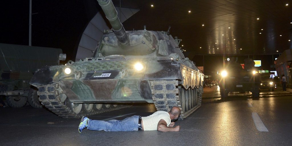 A man lies in front of a Turkish army tank at Ataturk airport in Istanbul, Turkey July 16, 2016. REUTERS/IHLAS News Agency NO SALES. NO ARCHIVES. TURKEY OUT. NO COMMERCIAL OR EDITORIAL SALES IN TURKEY.